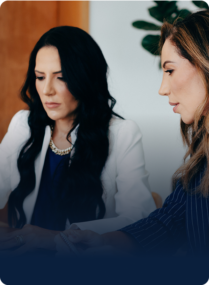 Sócias da Amlak Kallab, empresa especializada em gestão patrimonial, lado a lado, olhando para o notebook, concentradas